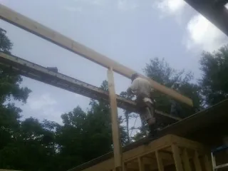 Carpenter setting a ridge beam over a new addition frame — Ice Dam Removal by Roofing Brothers in Livermore